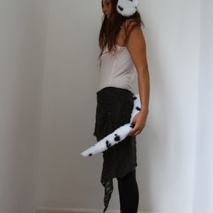 Op de afbeelding: Dalmati&euml;r kostuumset. De set bevat een zachte oorwarmers-stijl hoofdband en een bijpassende staart, beide wit met zwarte vlekken. Geschikt voor cosplay of thema-evenementen.