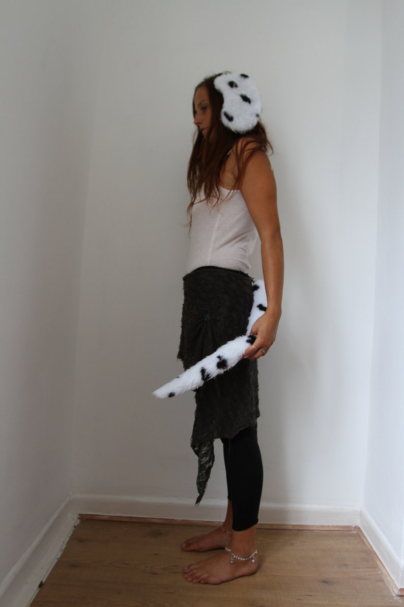 Op de afbeelding: Dalmati&euml;r kostuumset. De set bevat een zachte oorwarmers-stijl hoofdband en een bijpassende staart, beide wit met zwarte vlekken. Geschikt voor cosplay of thema-evenementen.