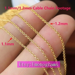 May include: Three gold cable chains, one 1.1 mm thick and two 1.2 mm thick, are shown on a finger. The chains are made of a smooth, round wire. The image is labelled "1.1mm/1.2mm Cable Chain Footage" and "Etsy: Umonograms".