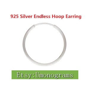 Op de afbeelding: Een zilveren endless hoop oorring gemaakt van 925 sterling zilver. De oorring is een simpel, klassiek ontwerp dat perfect is voor dagelijks gebruik.