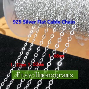 May include: A close-up of silver flat cable chain in various sizes. The chain is 925 silver and comes in 1.32mm, 1.52mm, and 1.68mm widths. The text "925 Silver Flat Cable Chain" and "Etsy: Umonograms" is visible in the image.