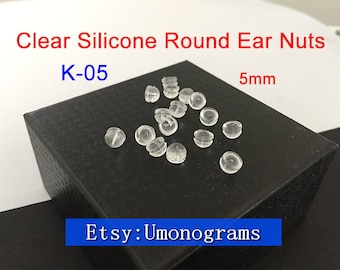 May include: Clear silicone round ear nuts, size K-05, 5mm, in bulk on a black surface.  Etsy: Umonograms