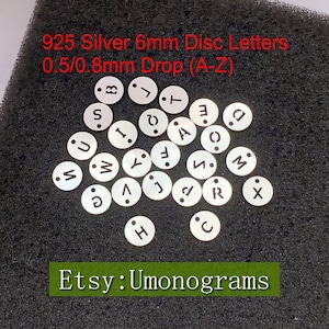 Dije con forma de disco redondo de 6 mm con letras (A-Z) y orificio superior único de 0,5/0,8 mm de grosor, 26 letras talladas en plata de ley 925, fabricado en EE. UU.