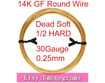 May include: A spool of 14K gold filled round wire, 30 gauge (0.25mm), in dead soft to 1/2 hard temper. The wire is gold colored and is wrapped around a black spool. The text "14K GF Round Wire", "Dead Soft 1/2 HARD", "30Gauge 0.25mm", and "Etsy: Umonograms" is printed on the image.