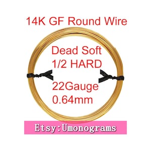 Puede incluir: Una bobina de alambre redondo de oro de 14 quilates, calibre 22, 0,64 mm de diámetro. El alambre está etiquetado como "Dead Soft 1/2 HARD". La bobina está envuelta con cinta negra. El texto "Etsy: Umonograms" es visible en la parte inferior de la imagen.