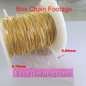 Può includere: Un rotolo di catena a scatola dorata, con due lunghezze di catena che si estendono dal rotolo. La catena è spessa 0,75 mm e 0,85 mm. Il testo "Etsy: Umonograms" è visibile nell'immagine.