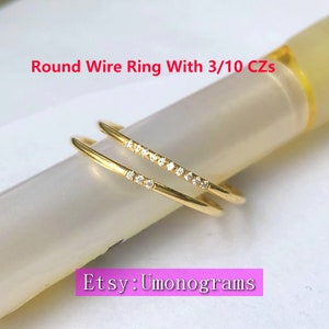 Op de afbeelding: Twee dunne gouden ringen met een rij kleine, heldere zirkonia-steentjes op elk. De ringen zijn op elkaar gestapeld. De tekst "Etsy: Umonograms" is zichtbaar in de rechterbenedenhoek van de afbeelding.