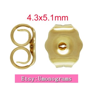 Puede incluir: Respaldos de pendientes de color dorado, de 4,3 x 5,1 mm. Los respaldos tienen un borde redondeado y festoneado y un pequeño agujero en el centro.