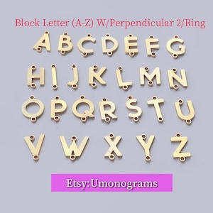 May include: Gold-colored block letter charms, A through Z, with perpendicular ring attachments. The letters are displayed on a light purple background. Text at the top reads "Block Letter (A-Z) W/Perpendicular 2/Ring". The Etsy shop name "Etsy:Umonograms" is at the bottom.