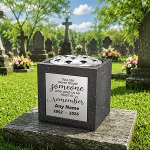 May include: A dark grey cube-shaped stone vase with a silver metal flower frog insert on top. The front features a silver plaque with the text: You can never forget someone who gave us so much to remember, Any Name, 1952 - 2026.