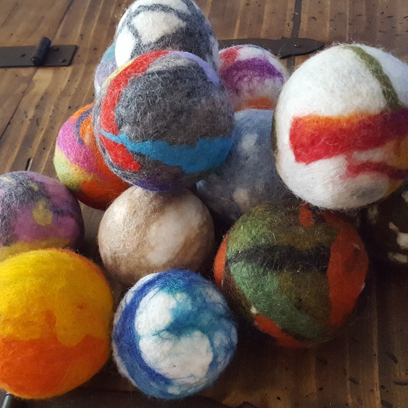 May include: A collection of colorful felt balls, each with a unique pattern. The balls are made of wool and are soft to the touch. They are perfect for adding a touch of whimsy to any room.