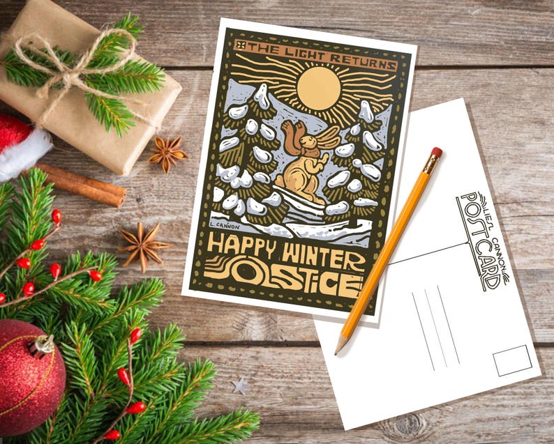 May include: A postcard with a winter scene featuring a rabbit in a snowy forest. The text on the postcard reads "The Light Returns" and "Happy Winter Solstice".