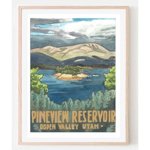 May include: A watercolor painting of Pineview Reservoir in Ogden Valley, Utah. The painting depicts a blue lake with a small island in the middle, surrounded by mountains and trees. The sky is a light blue with some clouds.
