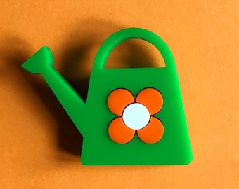 Broche acrylique WATERING CAN, un petit arrosoir avec une fleur orange