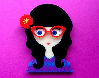 Maria acrylic brooch. A pinup style brunette who loves Tiki style, rock&#39;n roll. She wears an hibiscus flower in her hair.