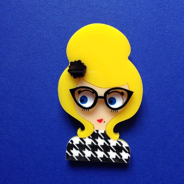 Broche acrylique DENISE. Blonde avec Chignon et barrette fleur noire, lunettes fifties et robe motif pieds de poule