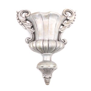 May include: A silver-colored wall-mounted decorative vase with ornate scrollwork and a fluted body. The vase has a classic, elegant design, perfect for adding a touch of vintage charm to any space. The vase is made of a durable material and is designed to be mounted on a wall.