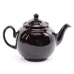 May include: A glossy, dark brown ceramic teapot with a rounded body, curved handle, and a spout. The lid has a small knob on top. The teapot is designed for brewing tea and has a classic, elegant appearance.
