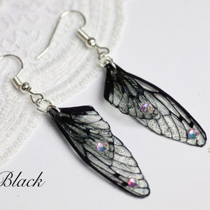May include: Black insect wing earrings with iridescent rhinestones. The wings are translucent with black veins and glitter.