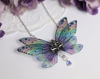 May include: A delicate iridescent butterfly necklace with a silver chain and a crystal pendant. The wings are translucent and have a rainbow sheen.