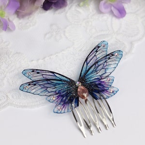 May include: A blue and purple butterfly hair comb with glitter and a pink rhinestone. The comb has five teeth.