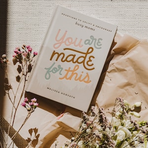 May include: A white book with the title "You are made for this" in colorful lettering. The book is titled "Devotions to uplift & encourage busy moms" and is by Melissa Horvath.
