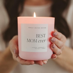 May include: Pink candle with a white label that reads "Sweet Water Decor" and "Best Mom ever". The label also lists the scent as "Jasmine, Rosemary, Sea Salt, Honey".