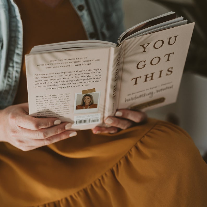 May include: A pink and white book with the title "You Got This" in brown text. The book is open and the back cover features a photo of a woman with the text "How can women keep up with life's demands without forgetting who God created them to be?"
