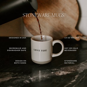 May include: A white stoneware mug with the text "Love You" in black. The mug is being filled with a dark liquid. The mug is 14 oz and is microwave and dishwasher safe. The design is on both sides.