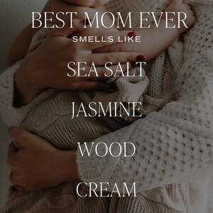 May include: A close-up image of a mother holding a baby. The text "BEST MOM EVER" is at the top of the image. The text "SMELLS LIKE" is below the first line of text. The text "SEA SALT", "JASMINE", "WOOD", and "CREAM" are stacked vertically below the second line of text.