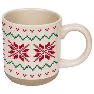 May include: A cream-colored ceramic mug featuring a repeating red and green pixelated snowflake and zigzag pattern. The mug has a smooth, glossy finish on the upper portion and a matte, unglazed base with a curved handle on the right side.