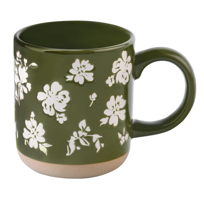 May include: A ceramic coffee mug with a dark green exterior and a light tan base. The mug is adorned with white floral patterns. The handle is a matching dark green. This mug is perfect for enjoying your favorite hot beverages.