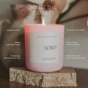 May include: A pink 15 ounce soy candle with a white label that says "Sweet Water Decor" and "XOXO". The candle has a burn time of 70+ hours and is made with non-toxic ingredients. The candle is phthalate free and has a 100% cotton wick.