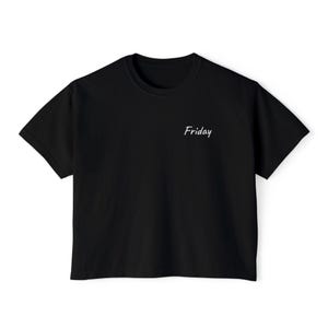 May include: Black t-shirt with the word "Friday" in white script on the upper left chest. The shirt has short sleeves and a crew neck. The fabric appears to be a soft, comfortable material.