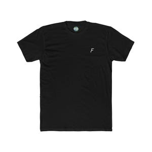 May include: Black crew neck t-shirt with a small white embroidered "F" on the chest. The shirt has a round neckline and short sleeves. A small circular tag is visible at the neckline.