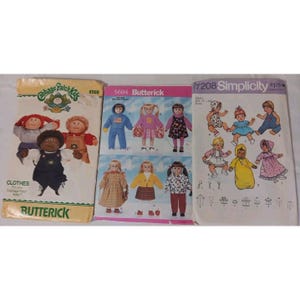 May include: Three vintage sewing patterns for dolls. The patterns include designs for Cabbage Patch Kids, Butterick, and Simplicity dolls. The patterns feature illustrations of the dolls in various outfits, including dresses, overalls, and athletic wear.