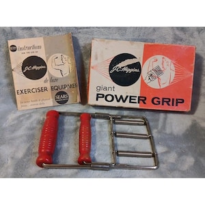 May include: Vintage J.C. Higgins exercise equipment set. Includes a hand grip exerciser with red handles, a box labeled "giant POWER GRIP", and an instruction booklet. The box and booklet have a retro design with the Sears logo.