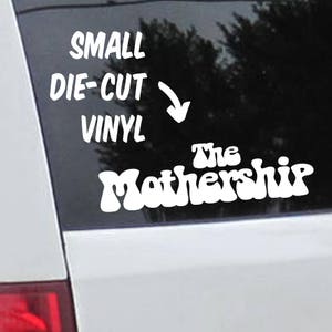 May include: White vinyl decal with the text "SMALL DIE-CUT VINYL" and an arrow pointing down. Below the text is the phrase "The Mothership" in a stylized font.