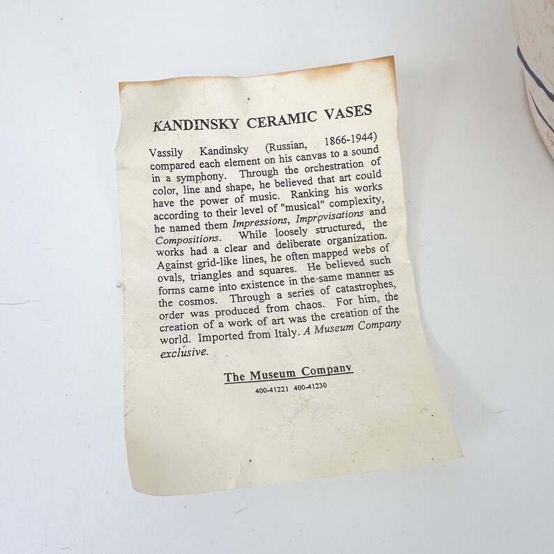 May include: A close-up of a cream-colored paper label with the text "KANDINSKY CERAMIC VASES." The label provides information about Vassily Kandinsky and his art. The Museum Company exclusive.