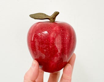 Pisapapeles antiguo de piedra roja con forma de manzana y vástago de latón.