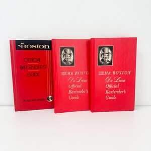 May include: Three red hardcover books with gold lettering. The books are titled "Mr. Boston Official Bartender's Guide" and "Old Mr. Boston De Luxe Official Bartender's Guide".