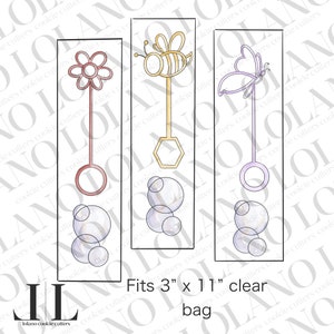 May include: Three cookie cutters shaped like bubble wands with different designs: a flower, a bee, and a butterfly. Each cutter has a handle and a circle at the top. The cutters are 7.6 cm by 28 cm and come in a clear bag.