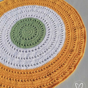 May include: A round crocheted rug with three concentric circles in yellow, white, and green.