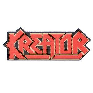 Op de afbeelding: Een geborduurde patch met het woord "Kreator" in een vet, gestileerd lettertype, in rood en geel.