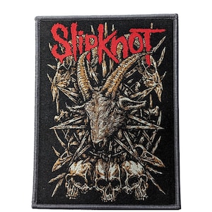 Könnte beinhalten: Schwarzer rechteckiger Aufnäher mit dem roten Bandnamen "Slipknot". Das Patch-Design zeigt einen Ziegenschädel, Totenköpfe und Knochenmotive. Der Aufnäher hat einen schwarzen Rand.