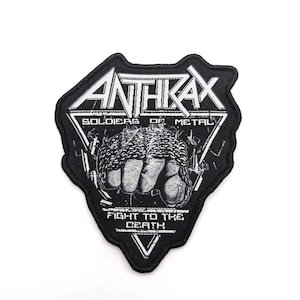 以下が含まれることがあります： バンド名「Anthrax」がダイヤモンド型に刺繍された黒と白の刺繍パッチ。ダイヤモンドの上に「Soldiers of Metal」、下に「Fight to the Death」の文字が書かれている。パッチには鎖で繋がれた拳が描かれている。