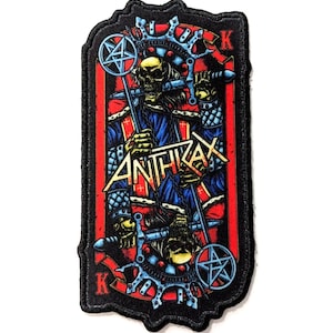 Könnte beinhalten: Schwarzer und roter gestickter Patch mit einem Schädel, der eine Krone trägt und ein Schwert und einen Stab hält. Der Patch zeigt den Bandnamen "ANTHRAX" in einer metallischen Schrift.
