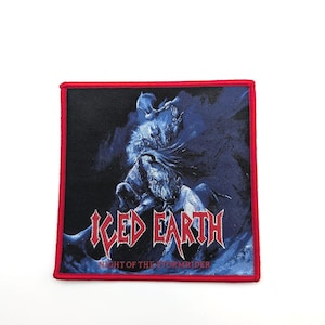 Può includere: Toppa quadrata con sfondo nero e bordo rosso. La toppa presenta un'illustrazione blu e bianca di una figura a cavallo, con le parole "ICED EARTH" e "NIGHT OF THE STORMRIDER" in rosso e bianco.