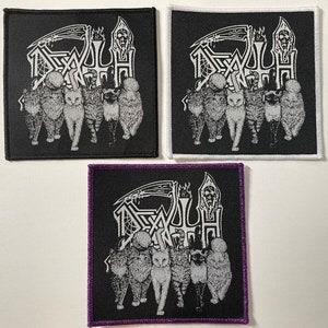 Könnte beinhalten: Drei schwarze Bügelbilder mit weißen Stickereien. Die Patches zeigen ein Bandlogo mit dem Wort "DEATH" und eine Sense mit einem Schädel am Ende. Die Patches sind von einem weißen Rand umgeben und haben einen lila Rand auf dem unteren Patch.