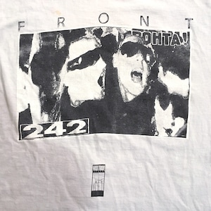 May include: White t-shirt with a black and white graphic print. The graphic shows a crowd of people with the word "FRONT" above the image. The number "242" is in a rectangle below the image, and the text "WAX TRAX!" is at the bottom.